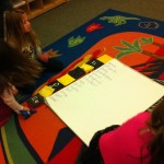Children measure chart paper with alphabet bean bags.